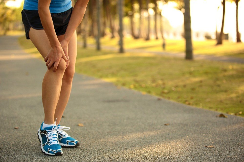 Hardloper houdt zijn pijnlijke knie vast